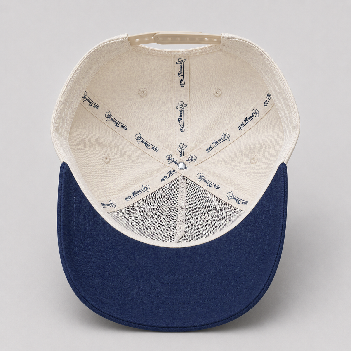 Beige TX snapback with navy visor, detail